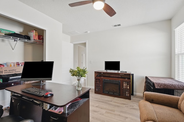 office with light wood-type flooring and a ceiling fan