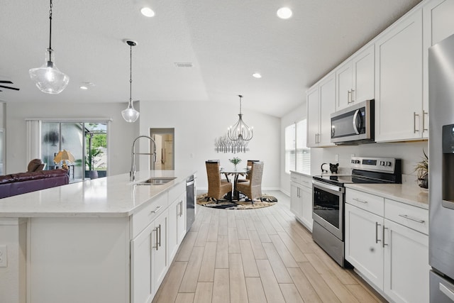 kitchen with stainless steel appliances, a sink, recessed lighting, healthy amount of natural light, and open floor plan