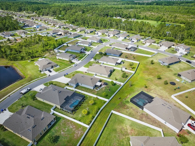 aerial overview of property's location with a heavily wooded area, a large body of water, and nearby suburban area