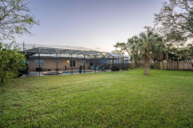 yard at dusk featuring a lanai and a fenced in pool