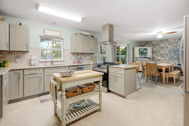 kitchen featuring hanging light fixtures, island exhaust hood, plenty of natural light, and stainless steel appliances