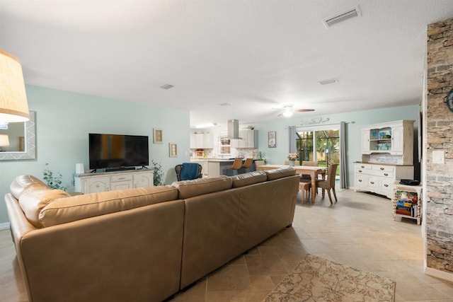 living room featuring light tile patterned floors and ceiling fan