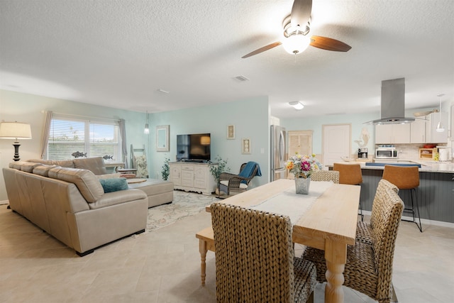 tiled living room featuring ceiling fan and a textured ceiling