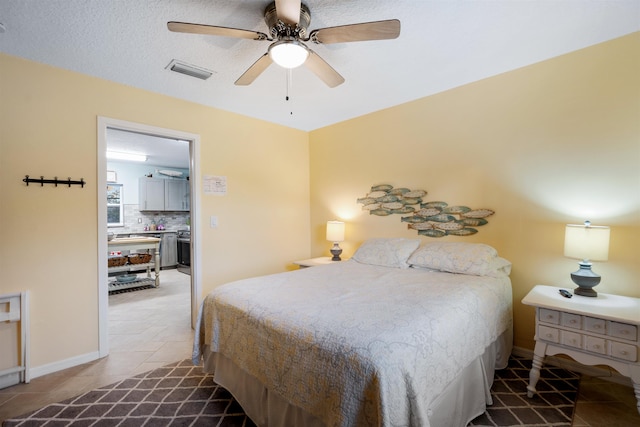 tiled bedroom with a textured ceiling and ceiling fan