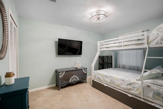 bedroom featuring a textured ceiling and a closet