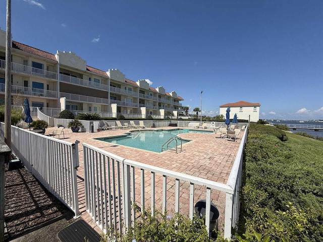 community pool featuring fence and a patio