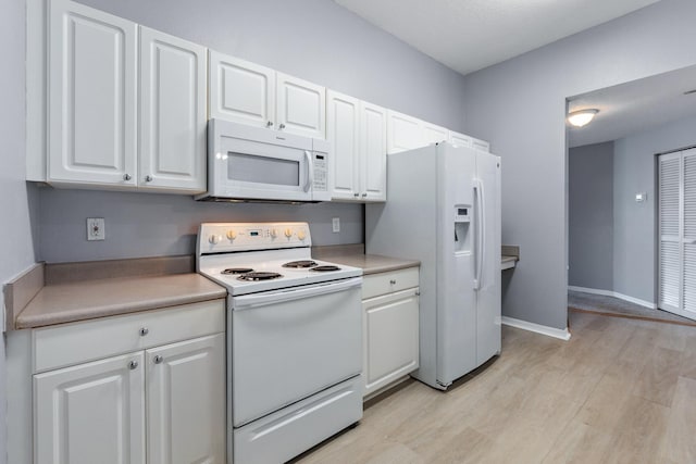 21211 Harbour Vista Cir, Saint Augustine, FL 32080 - kitchen with white appliances, white cabinetry, light wood finished floors, and light countertops