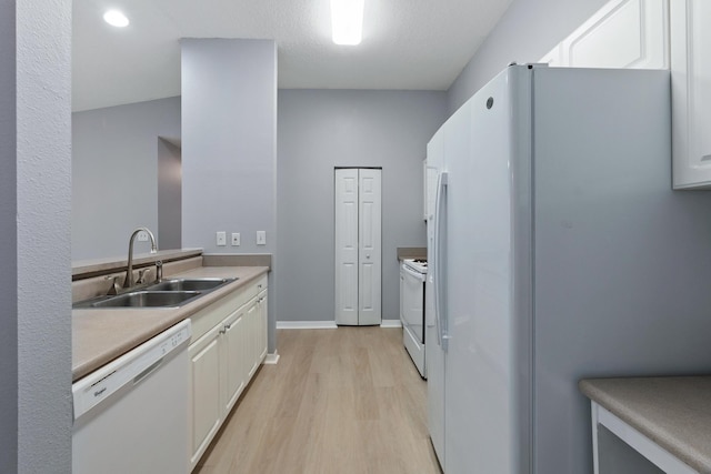 21211 Harbour Vista Cir, Saint Augustine, FL 32080 - kitchen with white appliances, light wood-style floors, white cabinetry, and light countertops