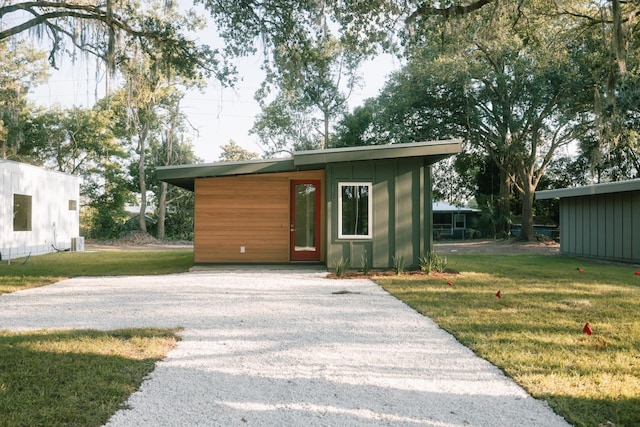 view of outdoor structure with a lawn and central AC