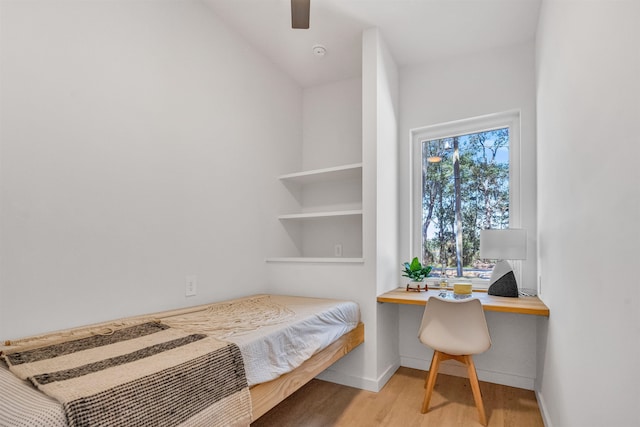 bedroom featuring built in desk, vaulted ceiling, and light wood-type flooring