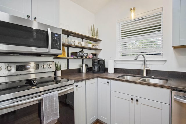5 Nesbit Ave, Saint Augustine, FL 32084 - kitchen featuring stainless steel appliances, open shelves, white cabinetry, and vaulted ceiling