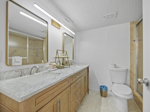 850 A1A Beach Blvd Unit 92, Saint Augustine, FL 32080 - bathroom featuring marble look tile flooring, double vanity, toilet, a textured ceiling, and an enclosed shower