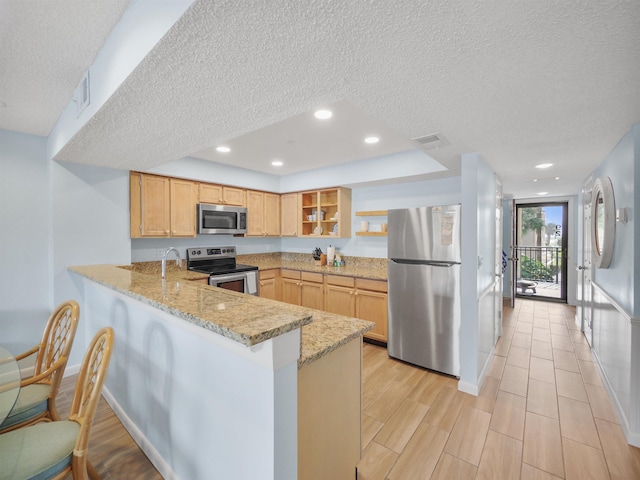 850 A1A Beach Blvd Unit 92, Saint Augustine, FL 32080 - kitchen featuring stainless steel appliances, a textured ceiling, open shelves, a peninsula, and baseboards