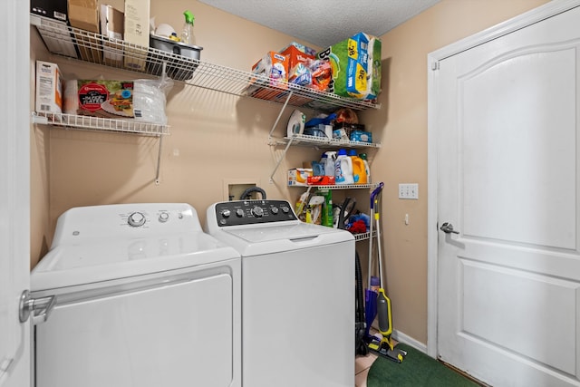 clothes washing area with washing machine and clothes dryer and a textured ceiling