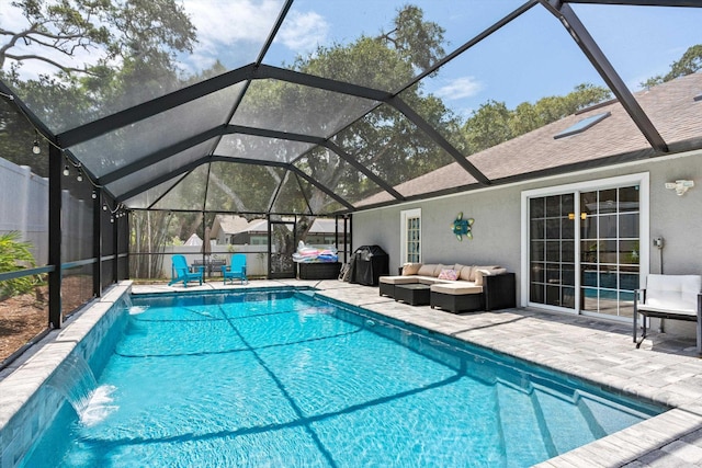 view of swimming pool with a lanai, outdoor lounge area, pool water feature, and a patio area