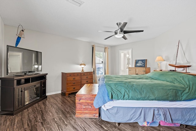 bedroom with ceiling fan, dark hardwood / wood-style flooring, and ensuite bathroom