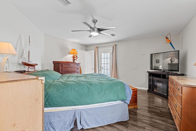 bedroom with dark hardwood / wood-style floors, ceiling fan, and a textured ceiling