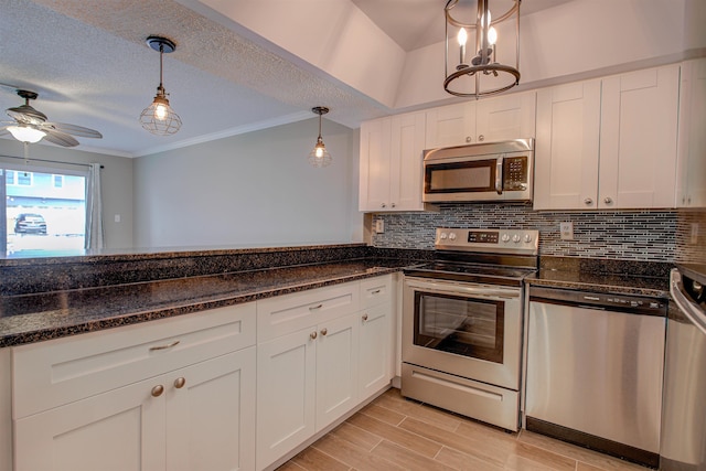 7175 A1A S A105, Saint Augustine, FL 32080 - kitchen featuring appliances with stainless steel finishes, decorative backsplash, white cabinets, ceiling fan, and hanging light fixtures