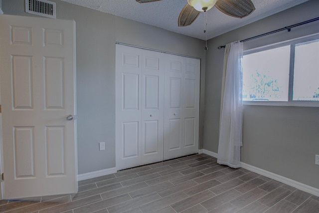 7175 A1A S A105, Saint Augustine, FL 32080 - unfurnished bedroom with baseboards, wood finished floors, a closet, a textured ceiling, and ceiling fan