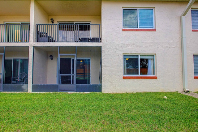 7175 A1A S A105, Saint Augustine, FL 32080 - rear view of house featuring stucco siding, a lawn, and a balcony