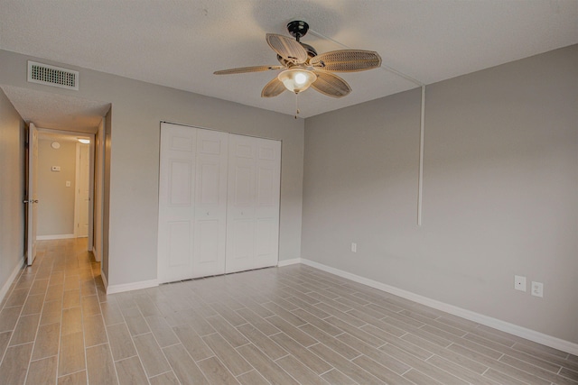 7175 A1A S A105, Saint Augustine, FL 32080 - unfurnished bedroom featuring baseboards, a closet, light wood-style flooring, and a textured ceiling