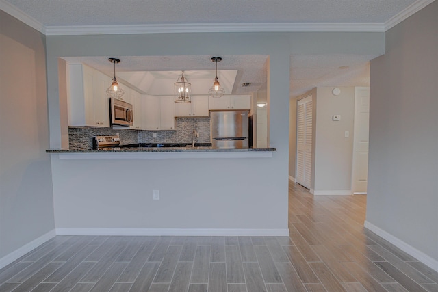 7175 A1A S A105, Saint Augustine, FL 32080 - kitchen featuring stainless steel appliances, light wood finished floors, tasteful backsplash, white cabinets, and a textured ceiling
