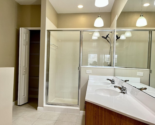 bathroom featuring a shower with shower door, vanity, and tile patterned flooring