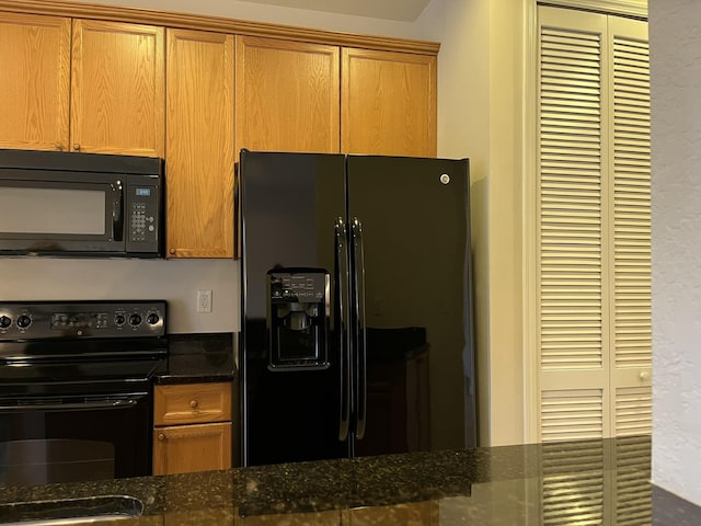 kitchen with black appliances and dark stone countertops