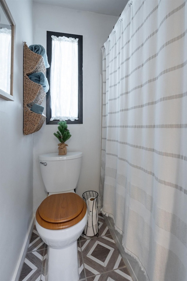 bathroom with tile patterned floors, plenty of natural light, toilet, and a shower with curtain