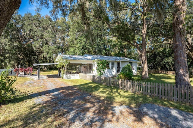 view of front of property featuring a front yard and a carport