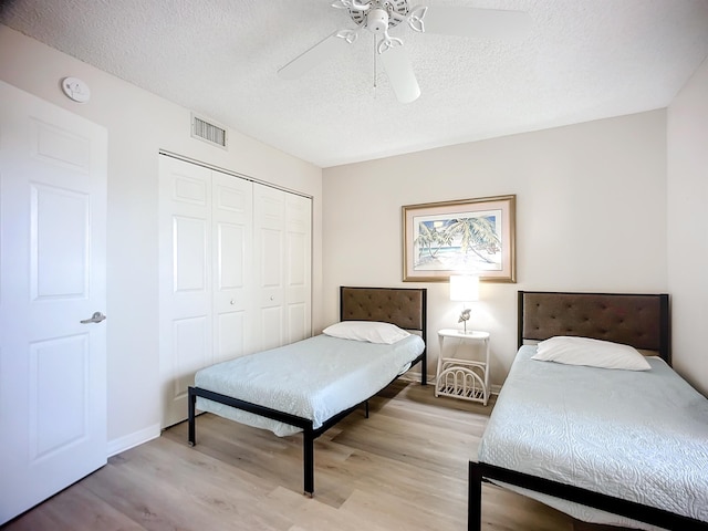 bedroom featuring ceiling fan, a closet, and light hardwood / wood-style floors