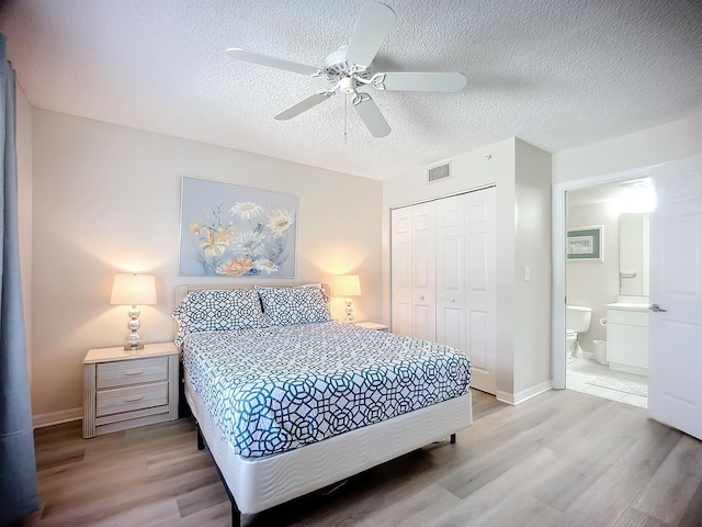 bedroom featuring a textured ceiling, light hardwood / wood-style floors, a closet, and ceiling fan