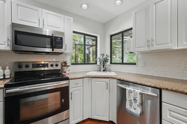 131 Boulder Rock Dr, Palm Coast, FL 32137 - kitchen featuring stainless steel appliances, white cabinetry, decorative backsplash, and recessed lighting