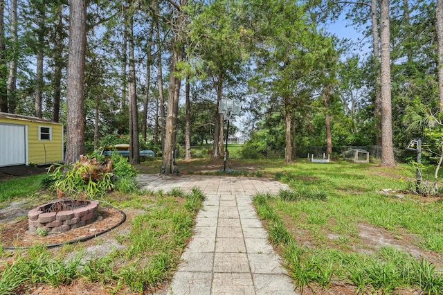 131 Boulder Rock Dr, Palm Coast, FL 32137 - view of yard featuring an outdoor fire pit, an outbuilding, and view of wooded area