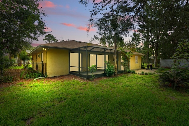 131 Boulder Rock Dr, Palm Coast, FL 32137 - rear view of house with a fenced backyard, glass enclosure, stucco siding, and a patio area