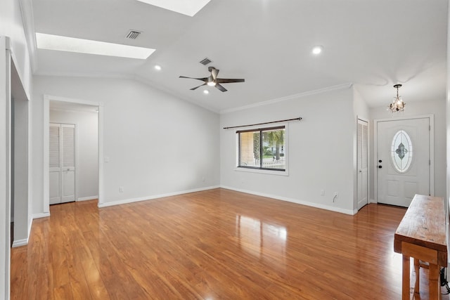 131 Boulder Rock Dr, Palm Coast, FL 32137 - unfurnished living room featuring light wood finished floors, a chandelier, a skylight, vaulted ceiling, and ceiling fan