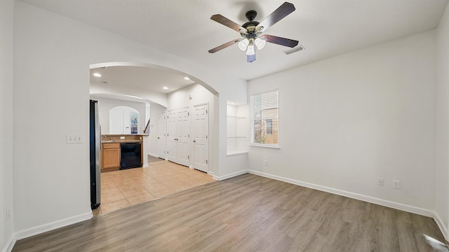 unfurnished living room featuring ceiling fan and light hardwood / wood-style flooring