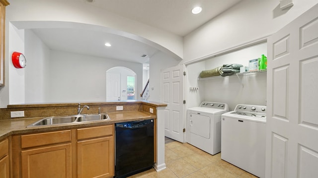 clothes washing area featuring washer and dryer, light tile patterned flooring, and sink