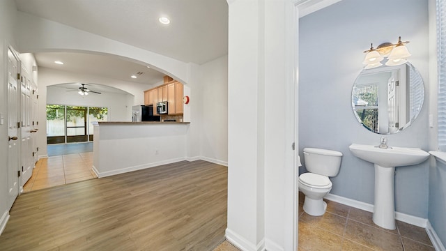 bathroom with ceiling fan, toilet, and wood-type flooring