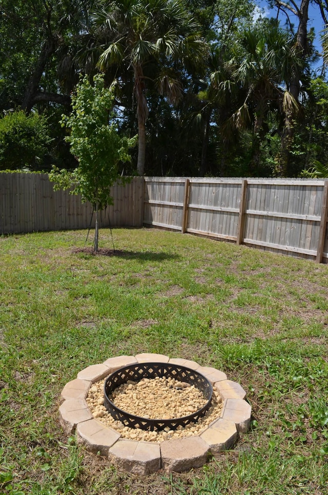 35 Putter Dr, Palm Coast, FL 32164 - fenced backyard with a fire pit