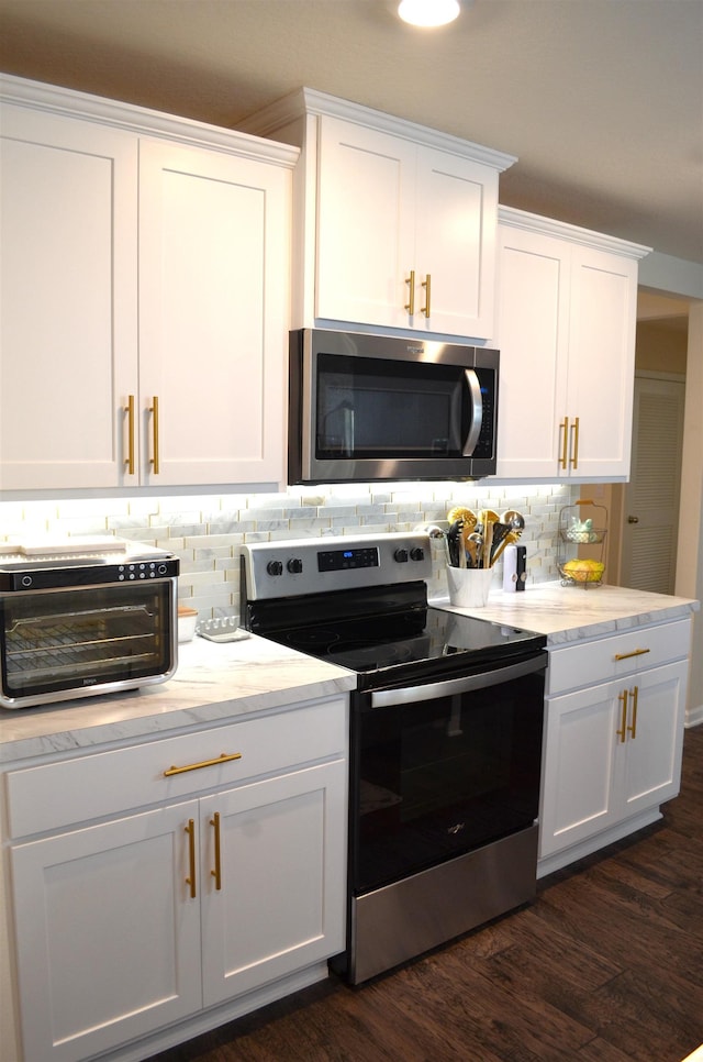 35 Putter Dr, Palm Coast, FL 32164 - kitchen with stainless steel appliances, white cabinets, tasteful backsplash, and dark wood-type flooring