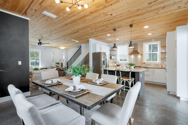 dining space with wooden ceiling, sink, a healthy amount of sunlight, and ceiling fan with notable chandelier