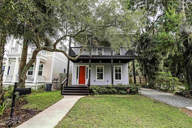 view of front facade with a balcony and a front yard