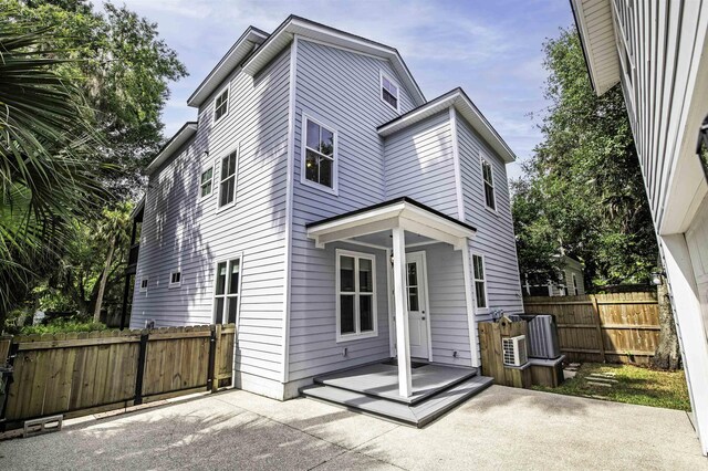 rear view of house featuring central air condition unit and a patio