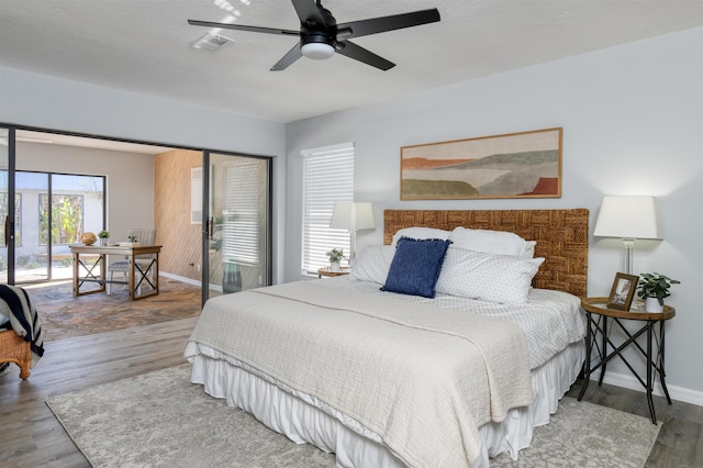 bedroom featuring hardwood / wood-style flooring, ceiling fan, access to exterior, and a textured ceiling