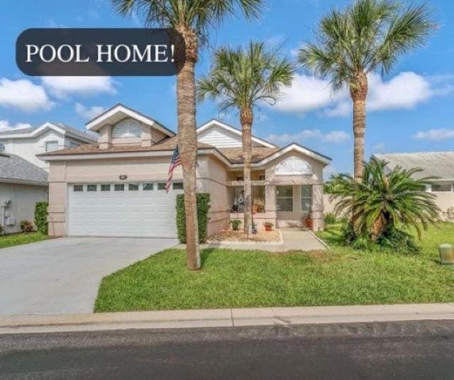 view of front of home with a front yard and a garage