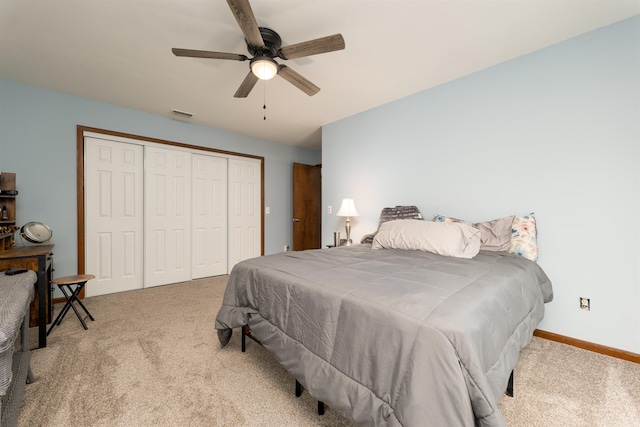 bedroom with ceiling fan, a closet, and light colored carpet