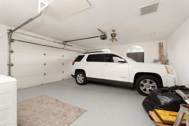 garage with independent washer and dryer and a garage door opener