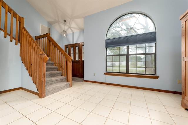 tiled foyer entrance with high vaulted ceiling