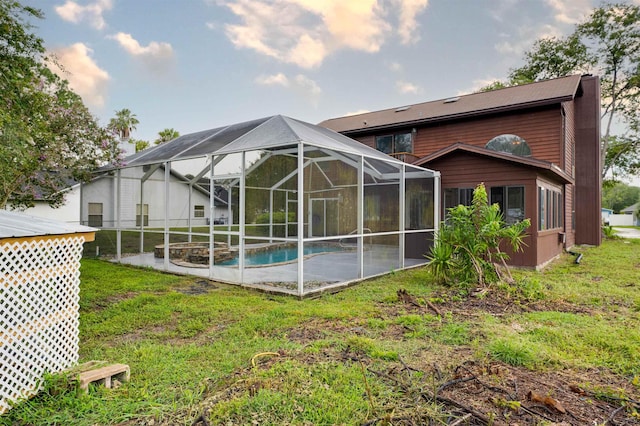 back of house with a lawn and glass enclosure